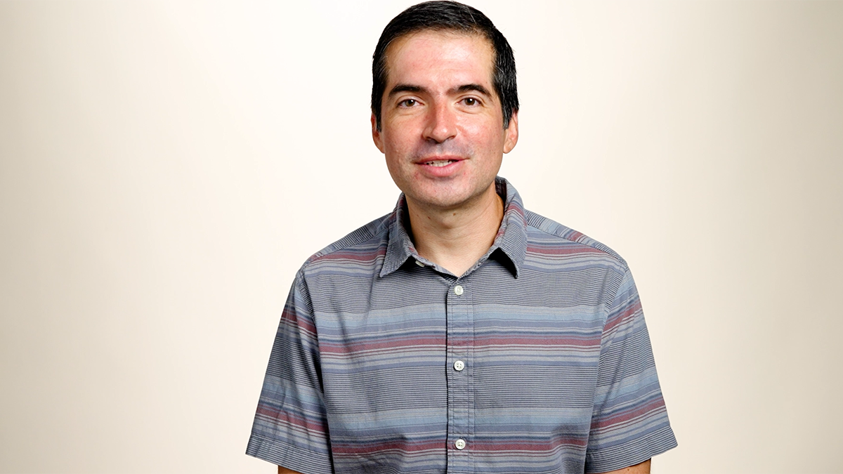 Portrait image of Gustavo Vejarano on blue background